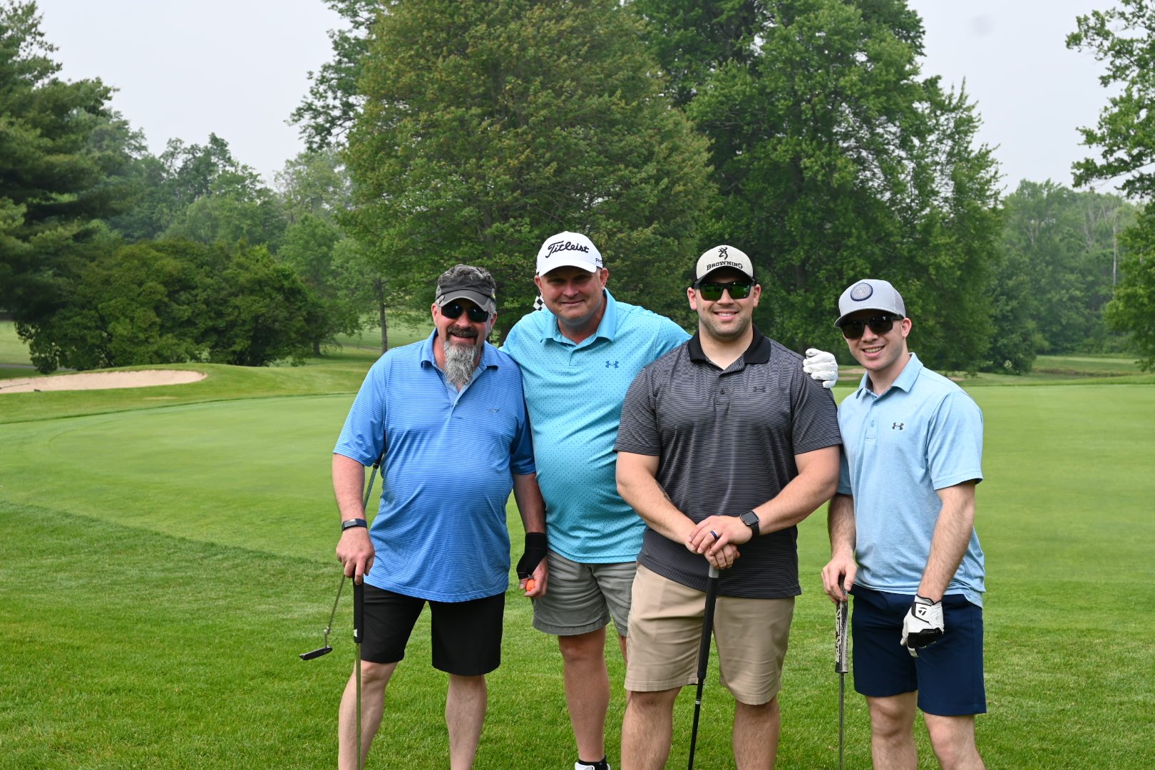 Four golfers smiling at camera